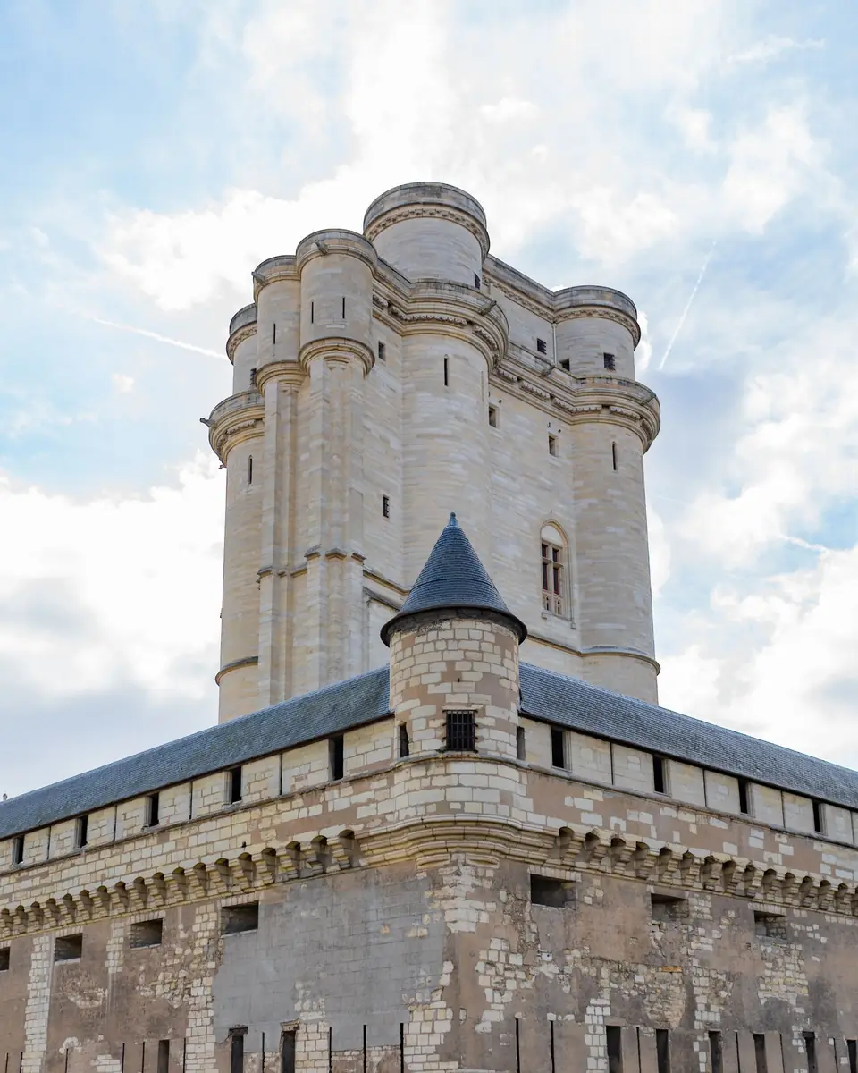 The keep of the Château de Vincennes rising behind a slate-capped corner turret of its walled enclosure
